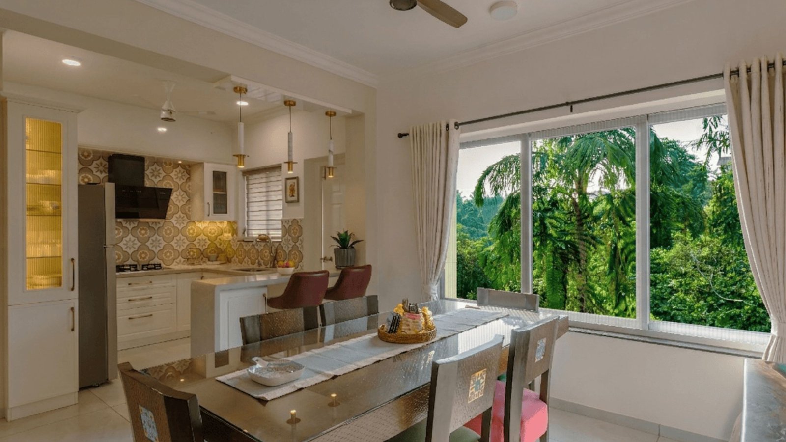Modern kitchen and dining area with a large window view of lush greene